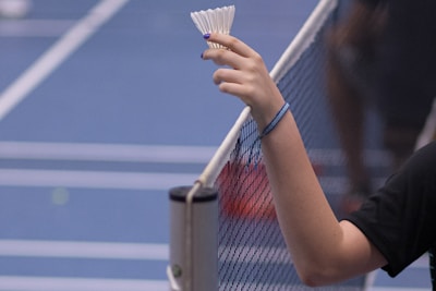 person holding white shuttlecock