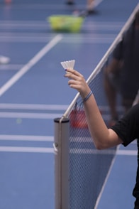 person holding white shuttlecock