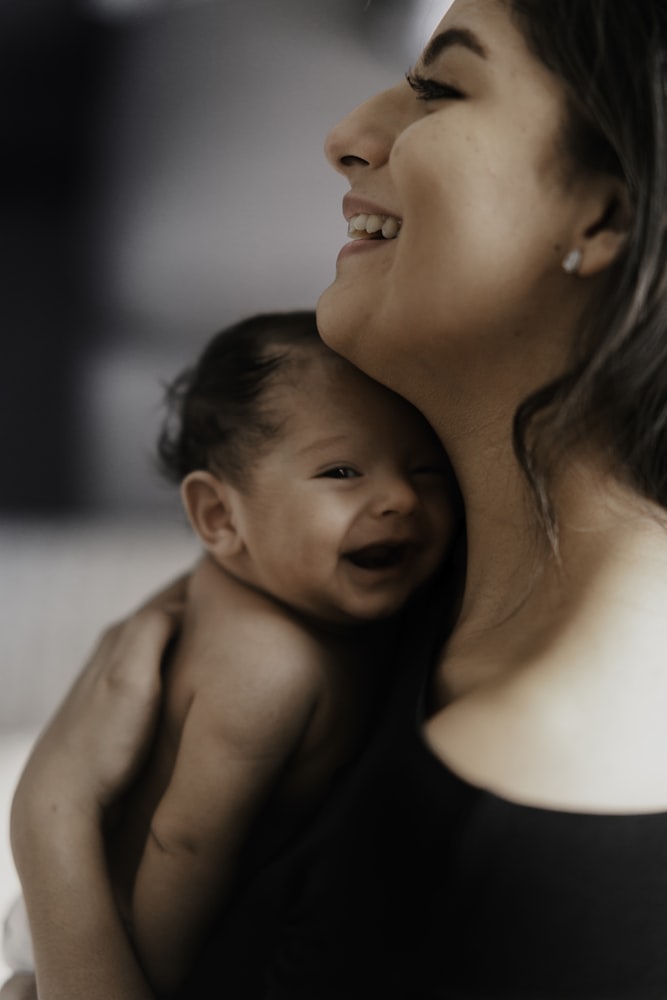 A woman carrying a smiling baby