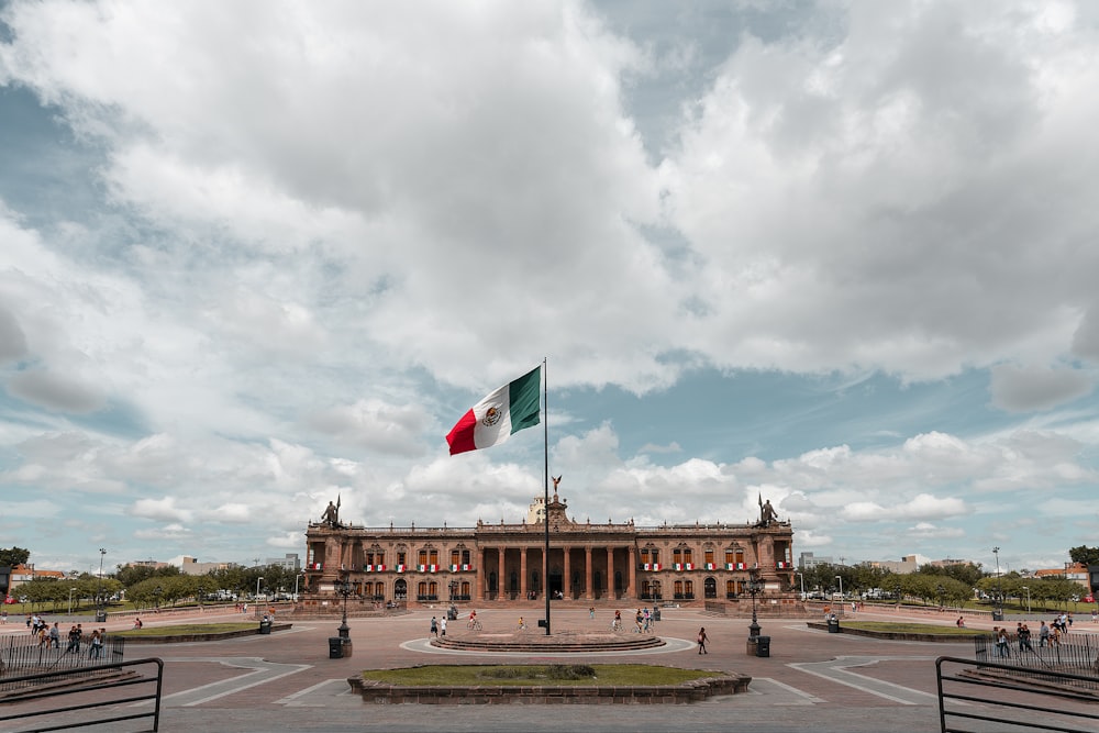 drapeau blanc, vert et rouge près du bâtiment pendant la photo de jour