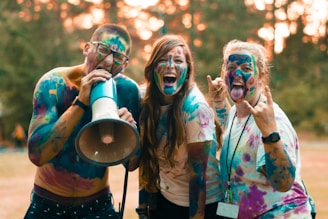 two woman and man full cover of Holi powder