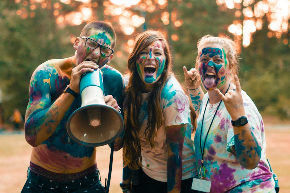 two woman and man full cover of Holi powder