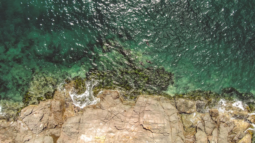 an aerial view of the ocean and rocks