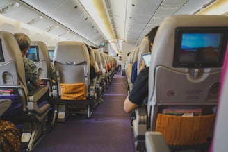 people sitting on chairs inside airplane