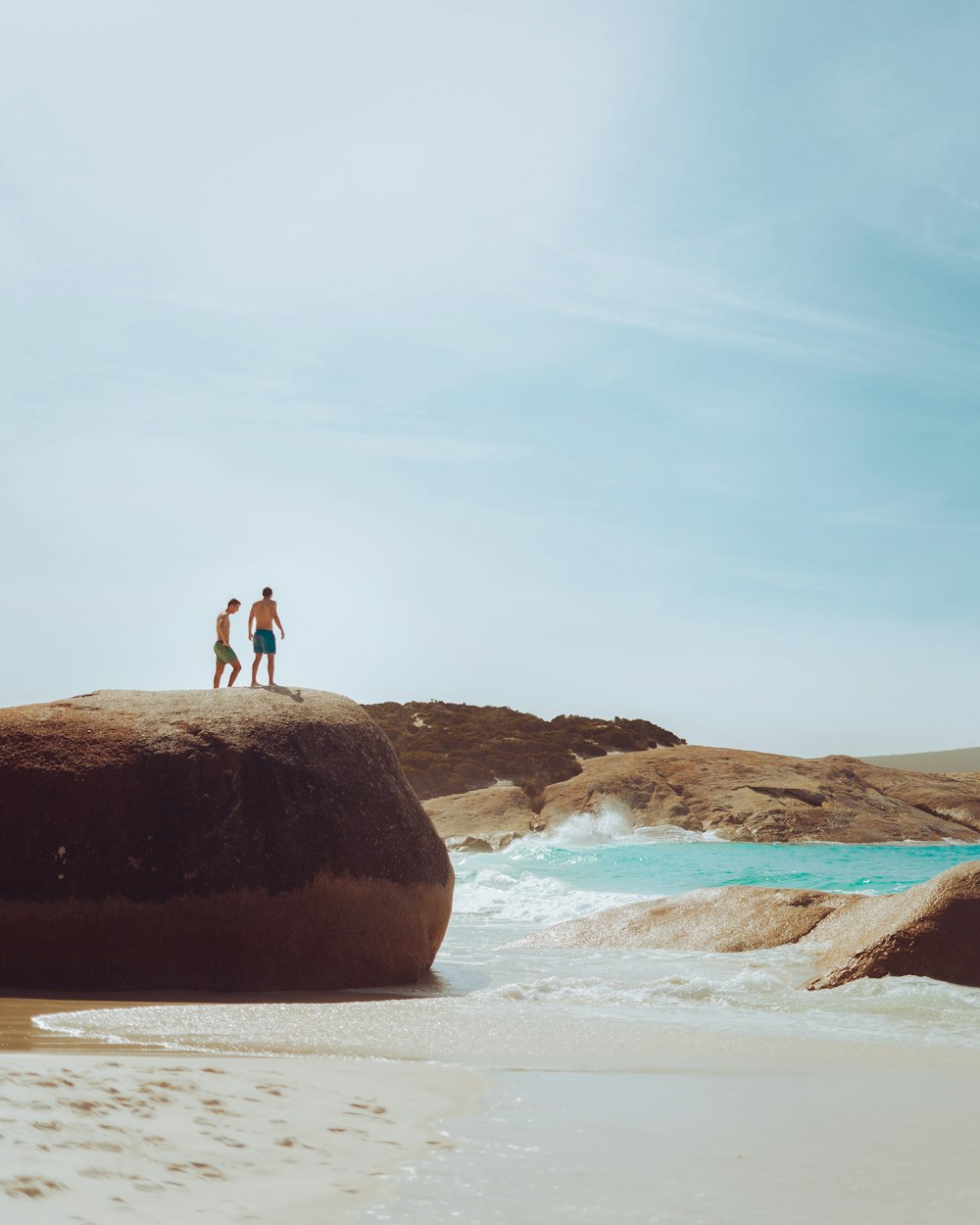 unknown persons standing on brown rock formation