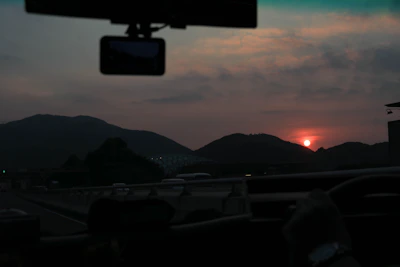 Scenic highway view with a car equipped with a Vistara dash cam driving into the sunset.
