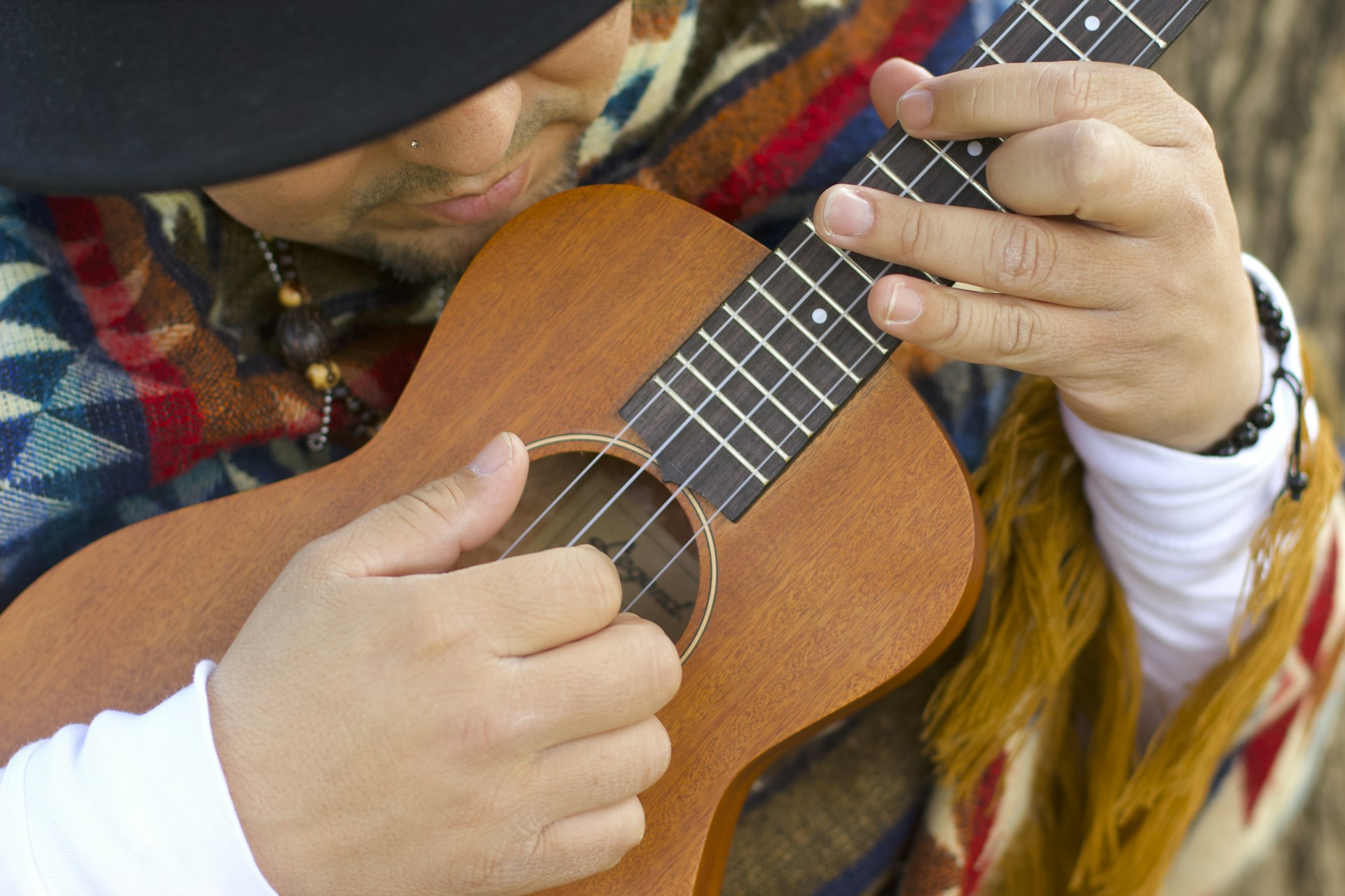 person playing brown ukulele