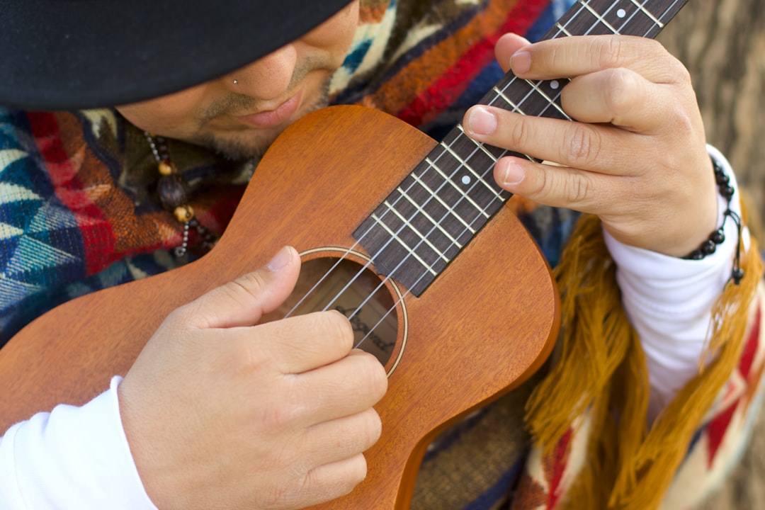 person playing brown ukulele