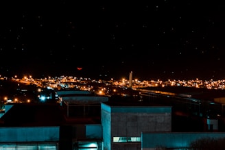 A nighttime cityscape with a subtle, glowing triangle in the sky.
