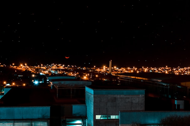 A nighttime cityscape with a subtle, glowing triangle in the sky.