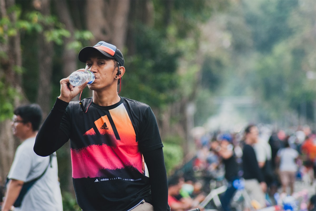Mann trinkt Wasser im Freien – Unterstützung für Wohlbefinden und Atemwege nach dem Rauchstopp
