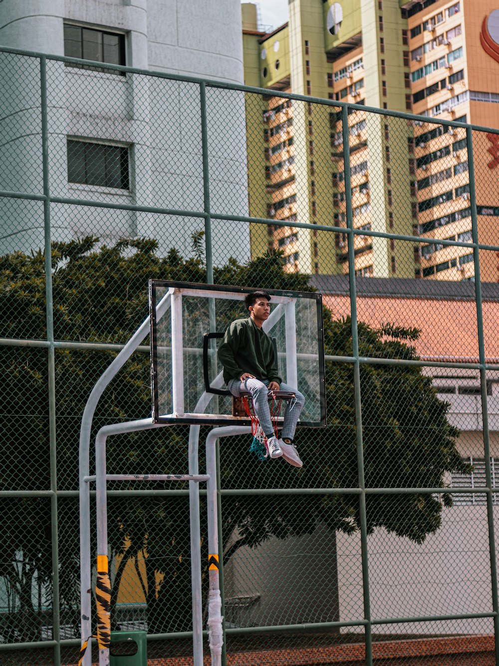 man sits on basketball hoop