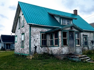 white brick house with green roof