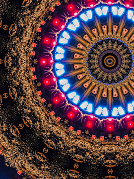 A kaleidoscopic pattern featuring concentric circles with intricate designs. The core is surrounded by smaller shapes that radiate outward, creating a symmetrical and visually dynamic effect.