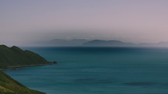 blue sea viewing mountain under white and gray sky in Paekakariki Hill Road New Zealand