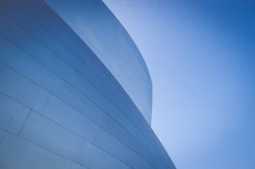 low-angle photography of blue glass walled building during daytime