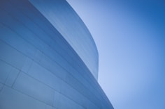 low-angle photography of blue glass walled building during daytime