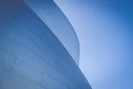 low-angle photography of blue glass walled building during daytime