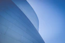 low-angle photography of blue glass walled building during daytime
