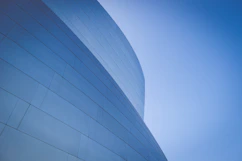 low-angle photography of blue glass walled building during daytime