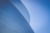 low-angle photography of blue glass walled building during daytime
