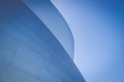 low-angle photography of blue glass walled building during daytime