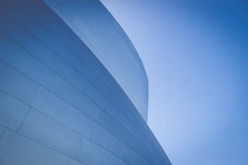 low-angle photography of blue glass walled building during daytime