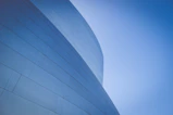 low-angle photography of blue glass walled building during daytime