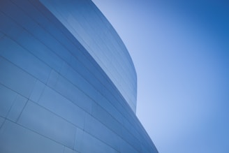low-angle photography of blue glass walled building during daytime