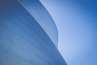 low-angle photography of blue glass walled building during daytime