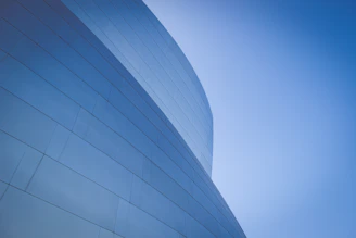 low-angle photography of blue glass walled building during daytime