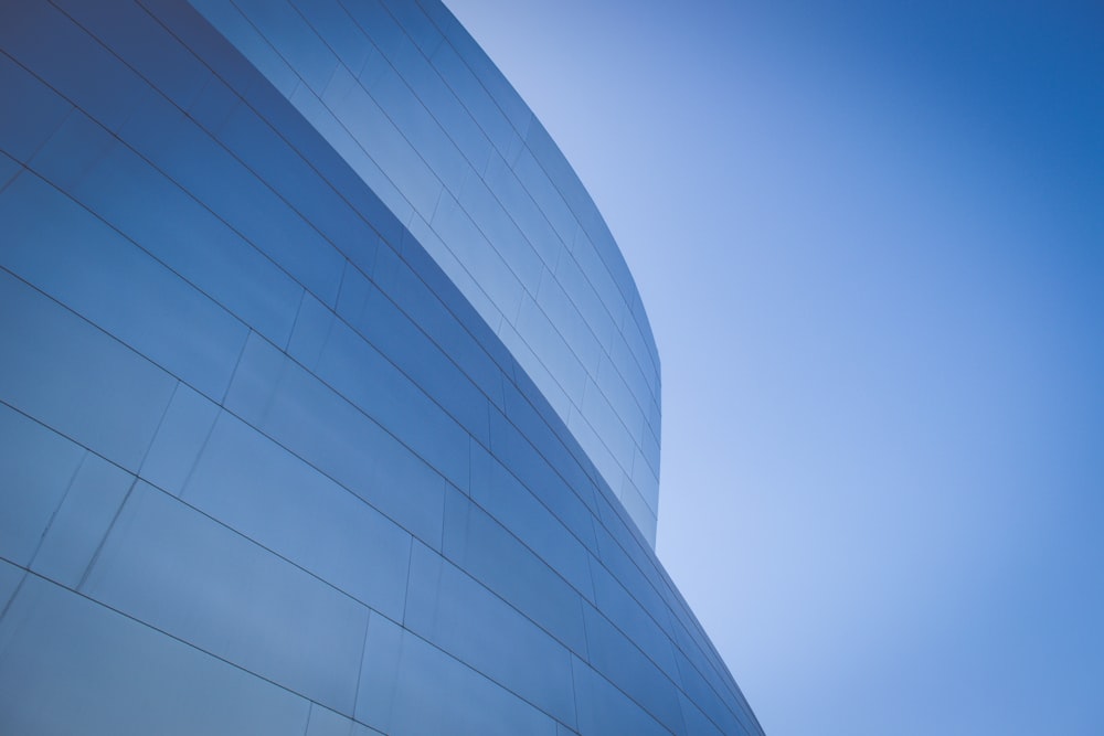 Fotografía de ángulo bajo de un edificio con paredes de vidrio azul durante el día