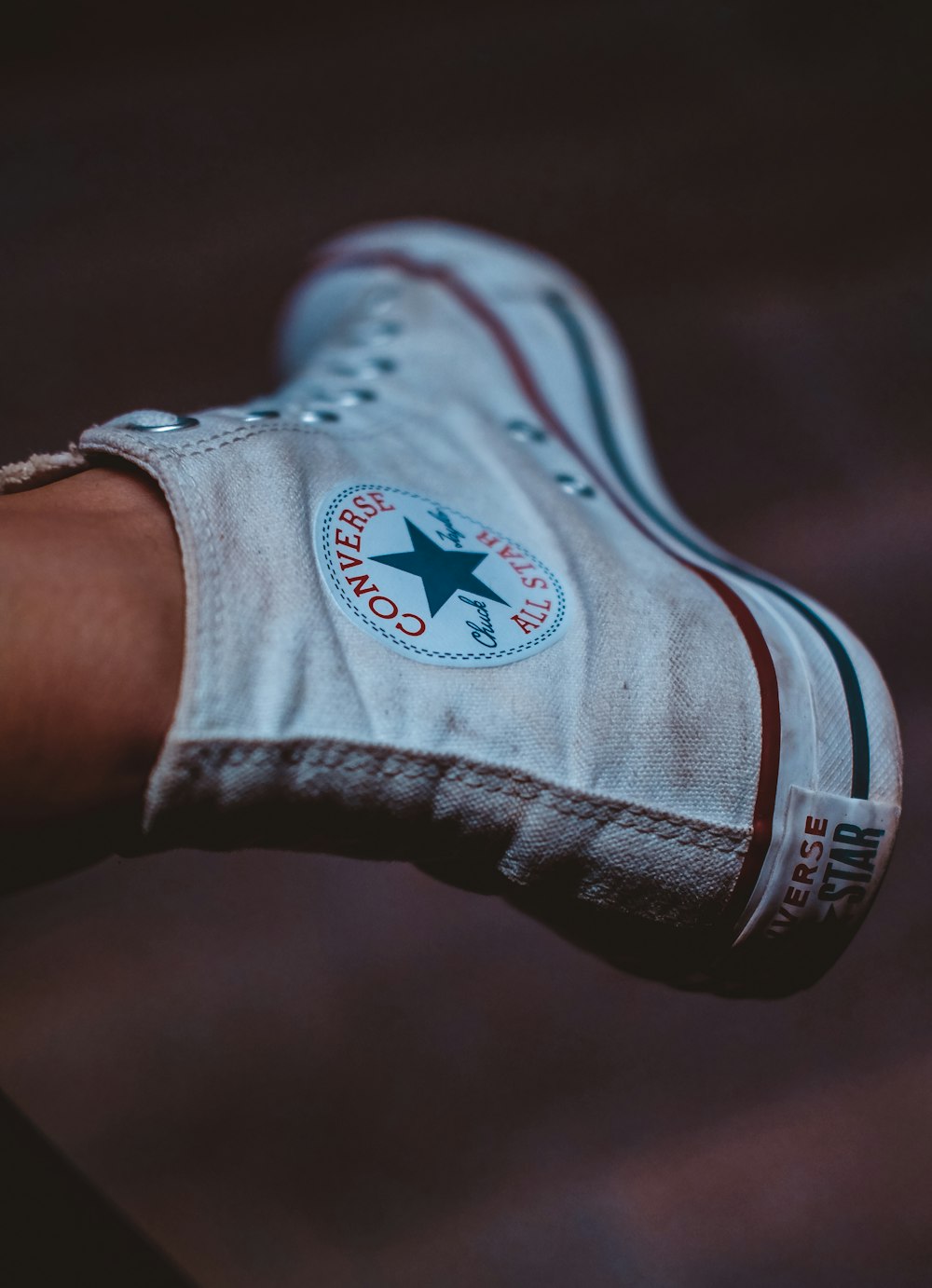 selective focus photography of person wearing white Converse All-Star high-top sneaker