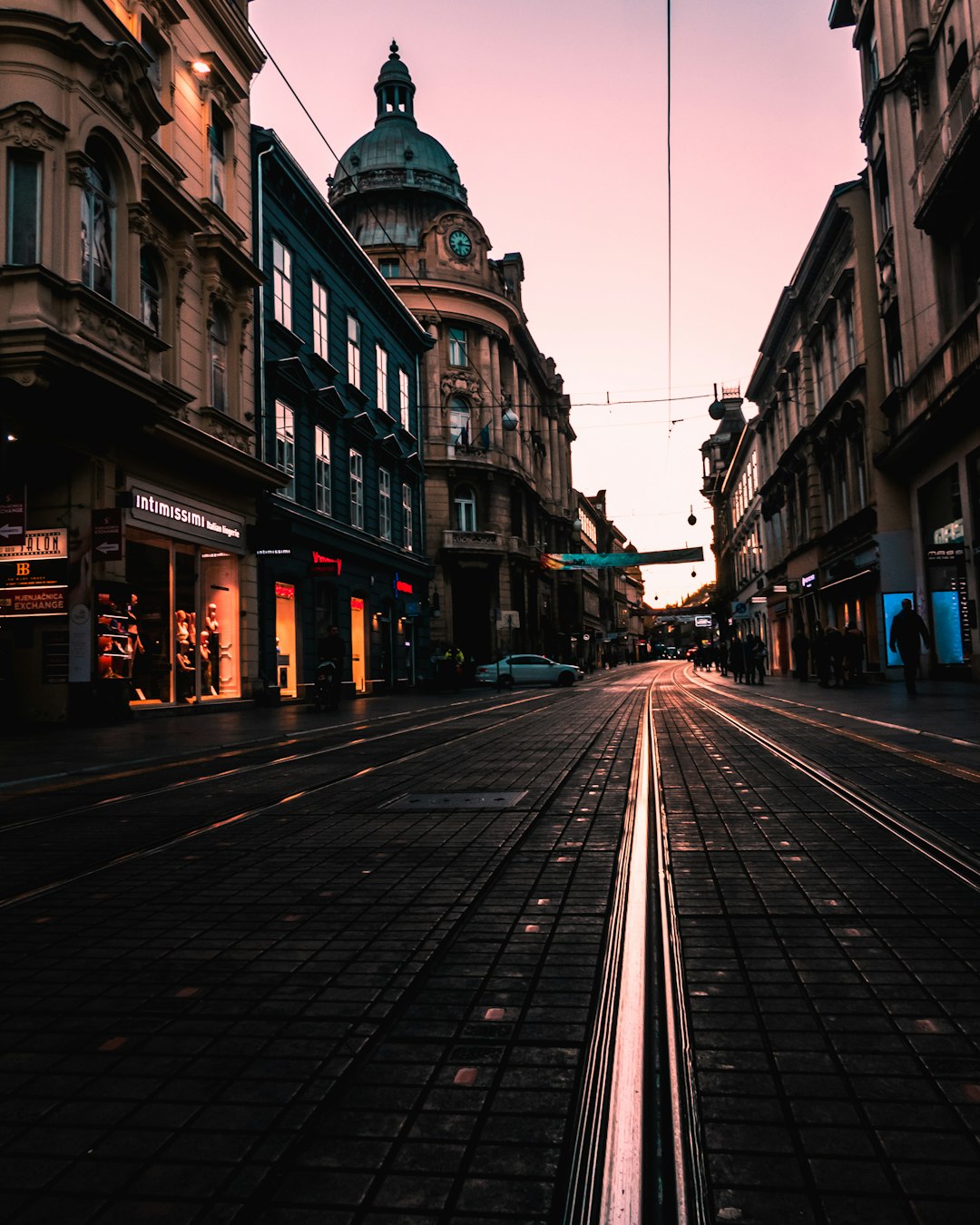 black concrete road between buildings at golden hour