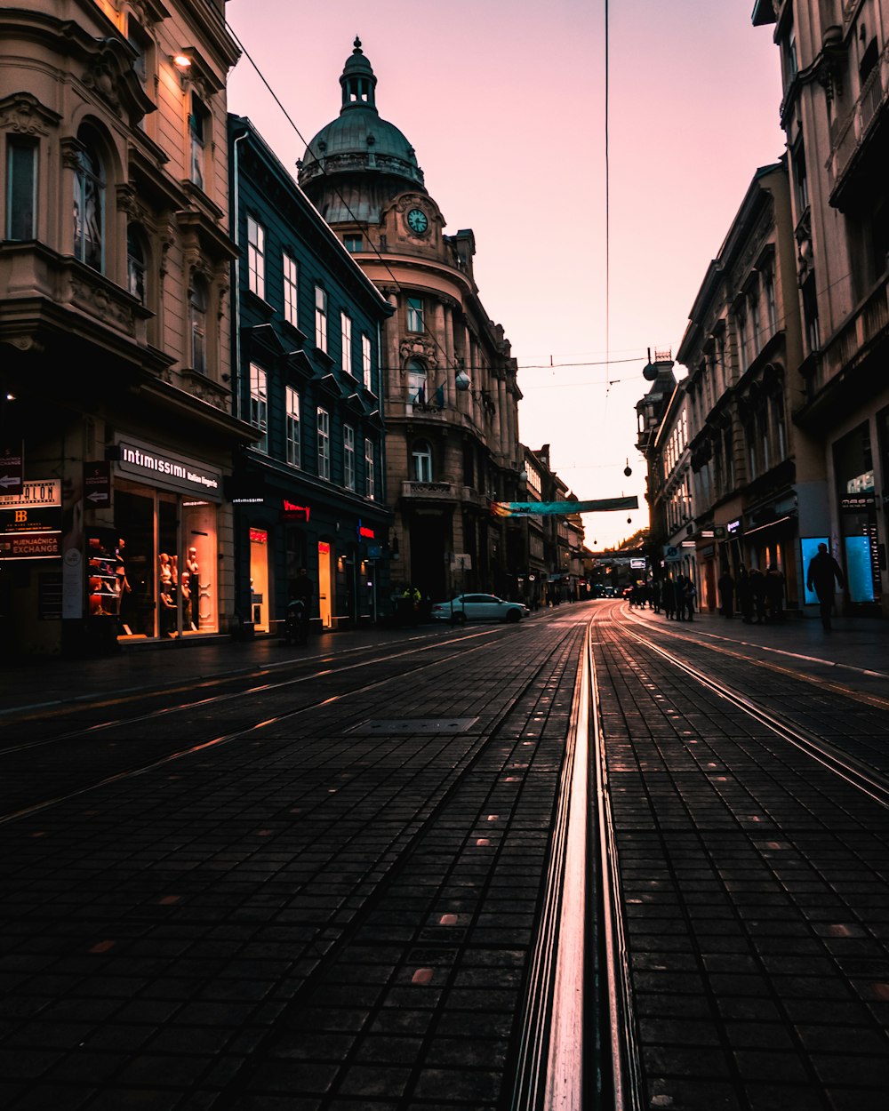 Schwarze Betonstraße zwischen Gebäuden zur goldenen Stunde