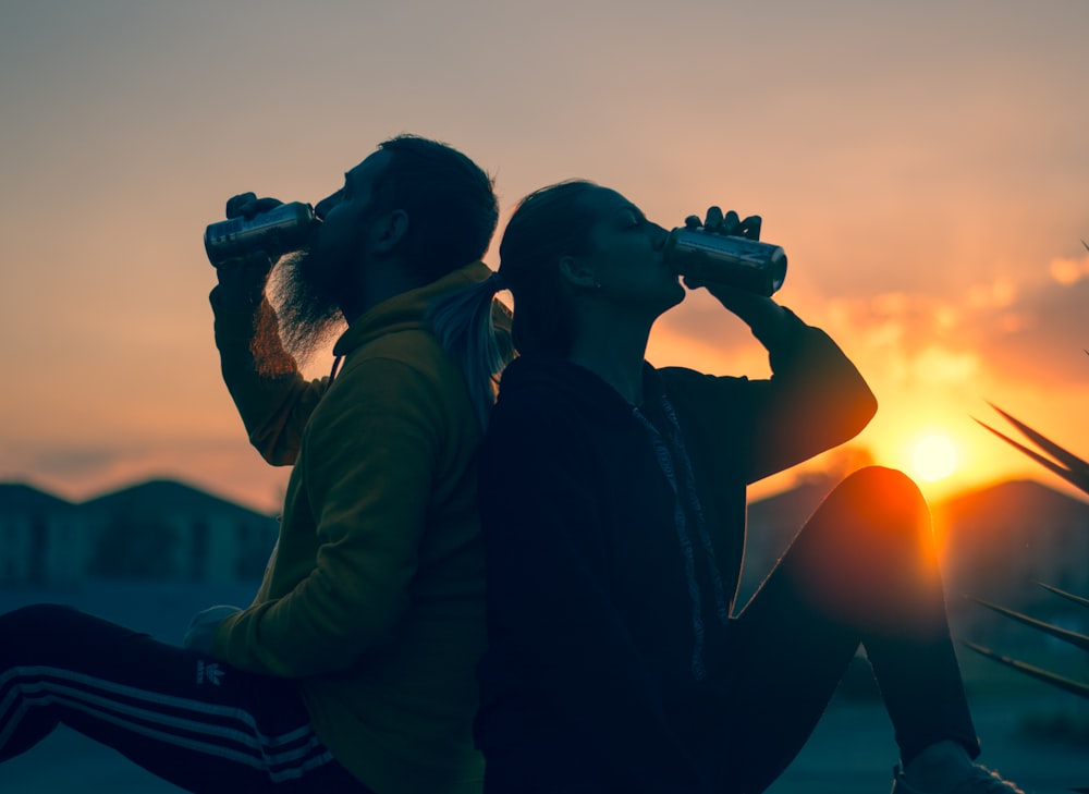 man and woman drinking tin cans