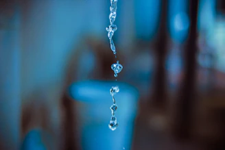 Close-up shot of water droplets falling from a diver’s mask in an underwater cave.