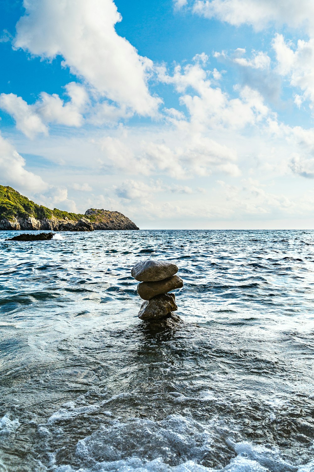 stock of stones on body of water during daytime