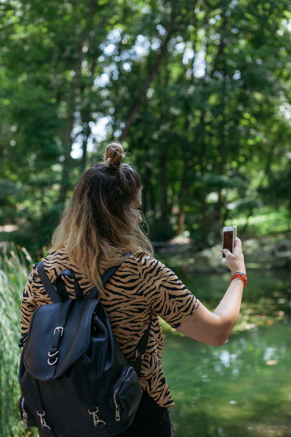 woman in brown top using smartphone