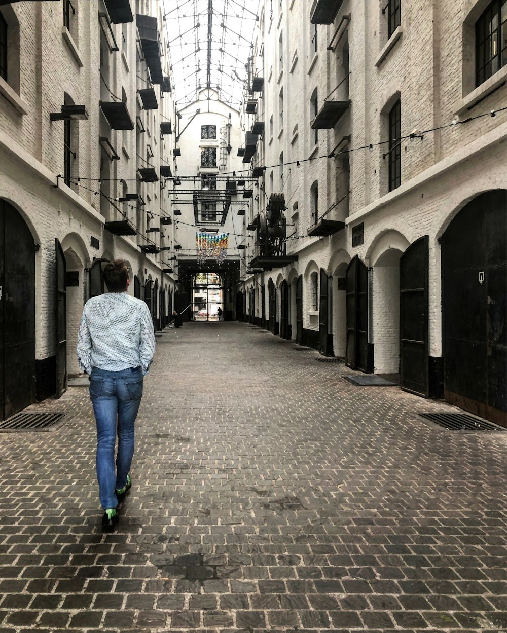 person walks on the hallway between buildings