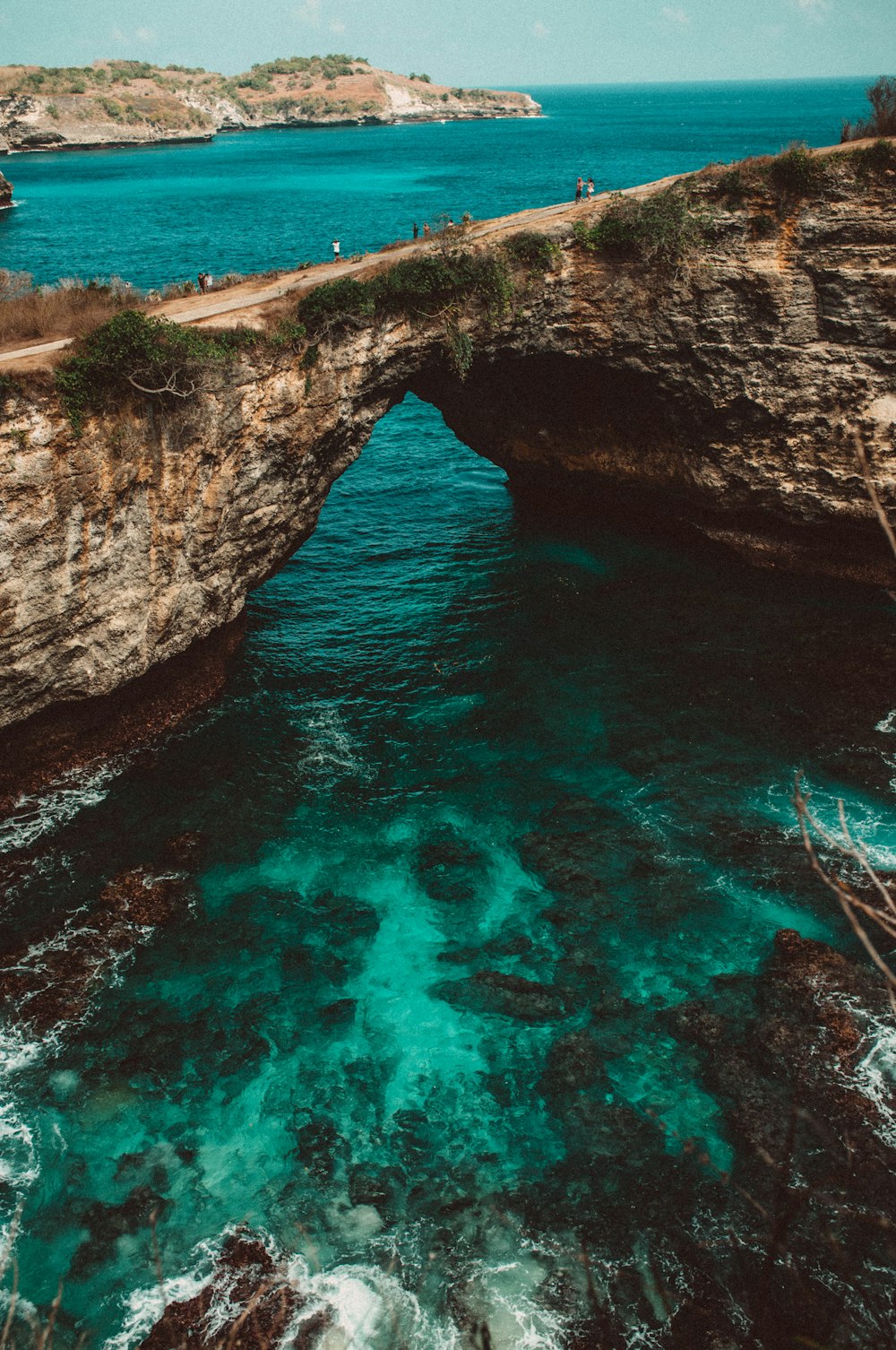 body of water beside rock formation at daytime