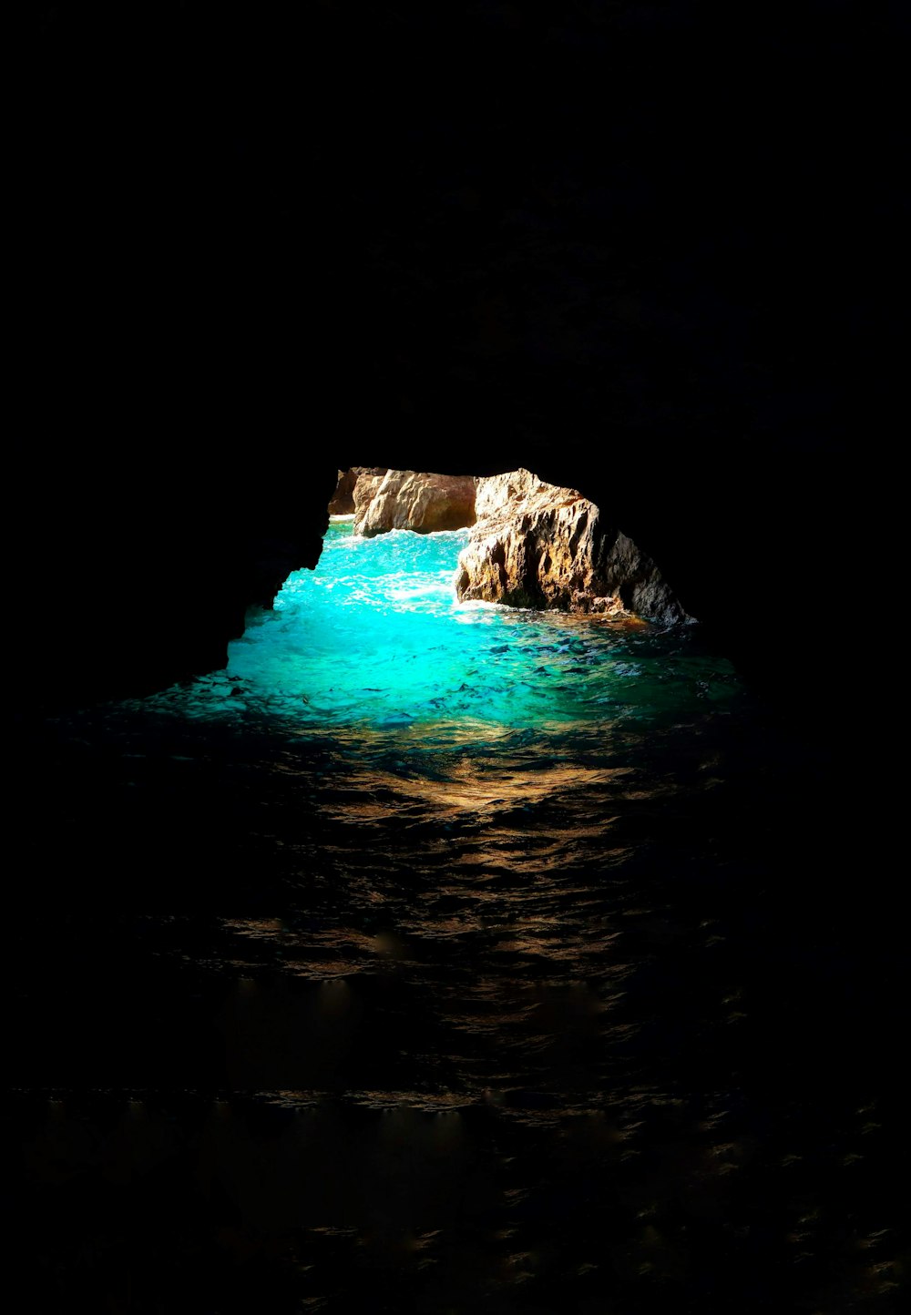 wavy ocean under cave