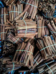 Workers carefully packaging cinnamon sticks in eco-friendly boxes inside a clean, modern facility.