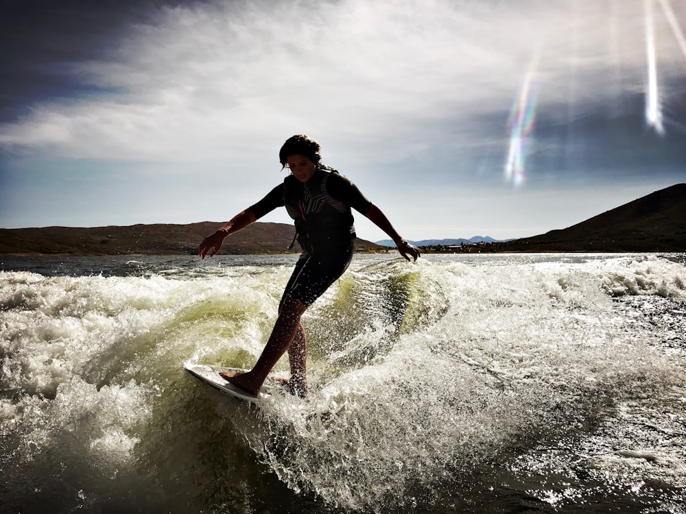 person riding wakeboard on body of water