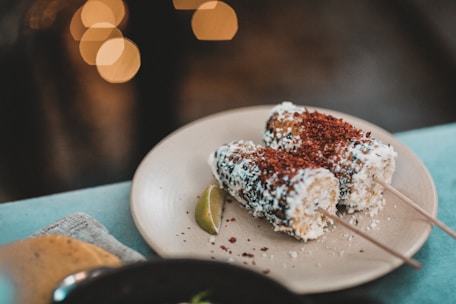 A cheerful gathering of people enjoying snacks and elotes at a party.