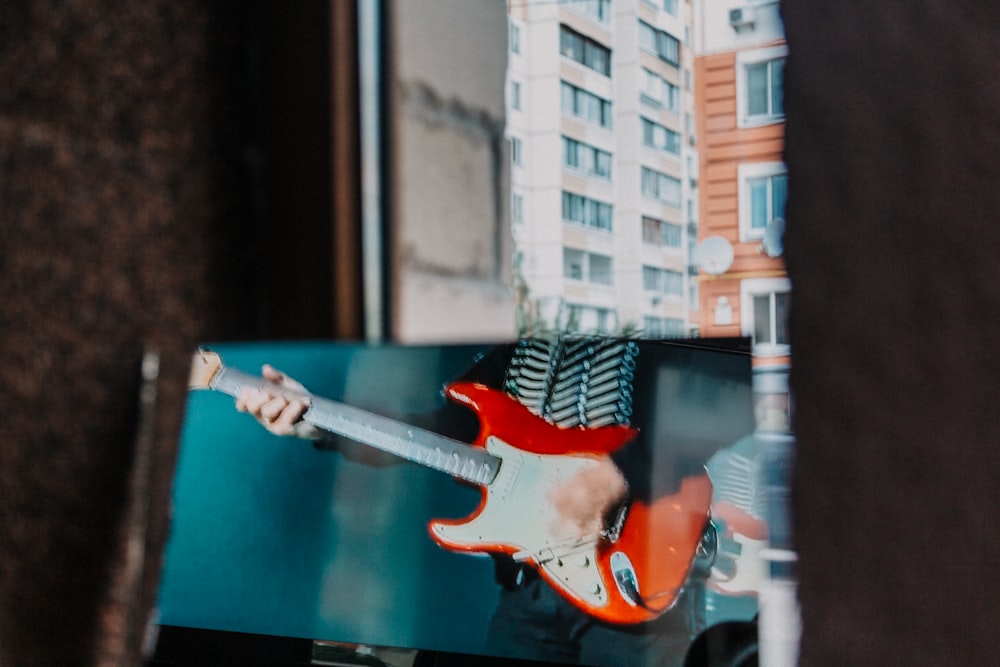 photo of red and white stratocaster electric guitar