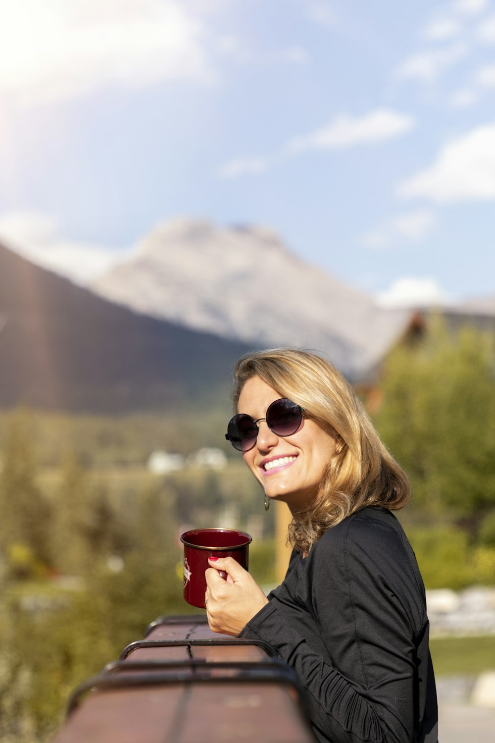 woman holding red ceramic mug close-up photography