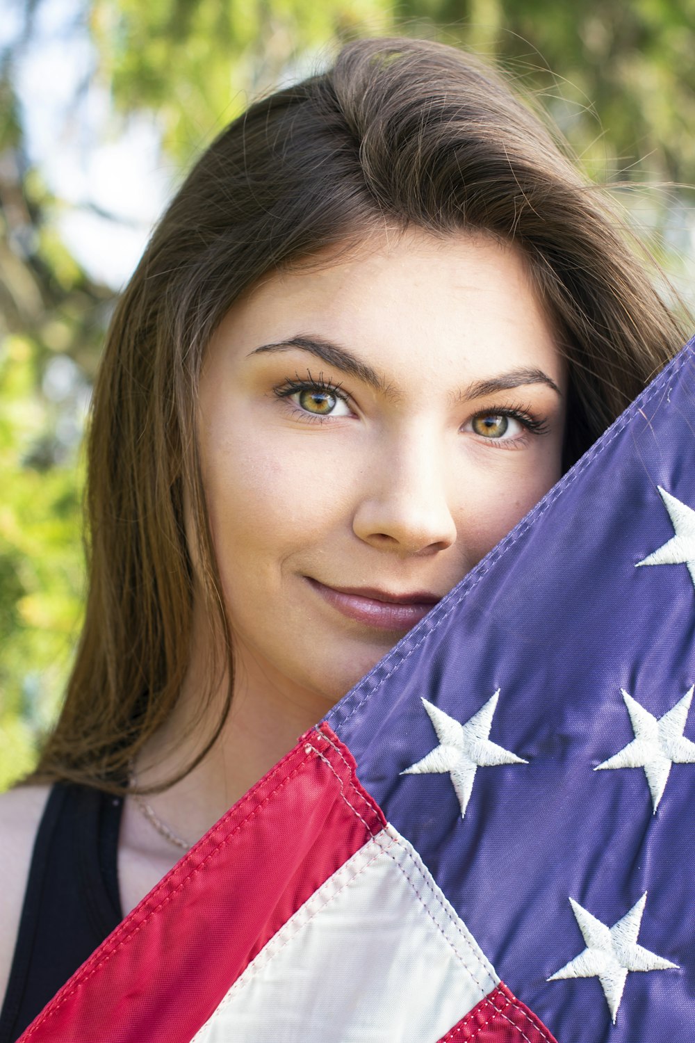 woman holding blue, white, and pink flag