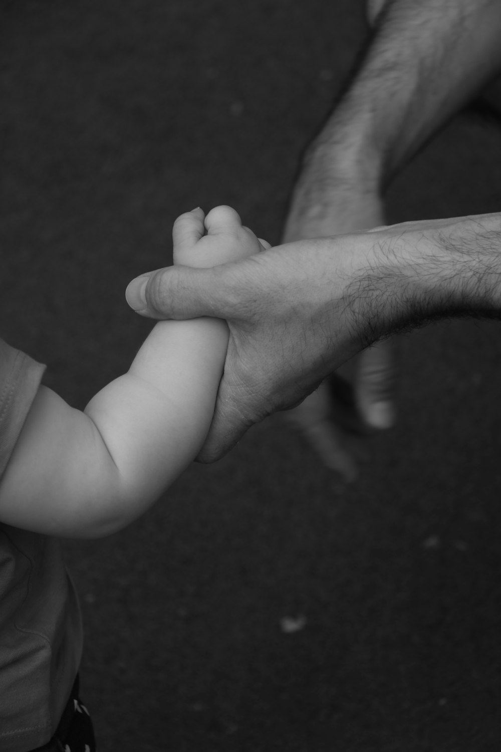 grayscale photo of person holding toddlers