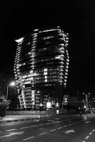 Completed modern building illuminated by solar-powered street lighting at night.